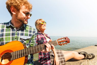 Genç kadın için gitar çalmak hipster adam.