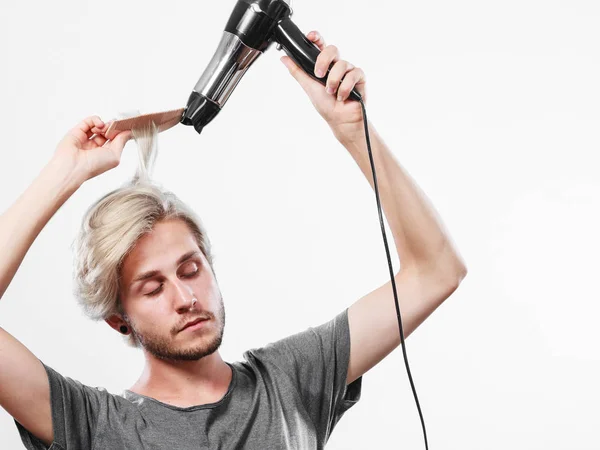 Joven hombre secando el cabello con secador de pelo — Foto de Stock