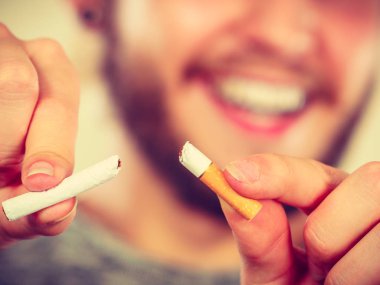 Güleryüzlü adam sigara kırılıyor