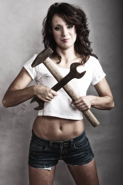 Sexy girl holding hammer and wrench spanner — Stock Photo, Image