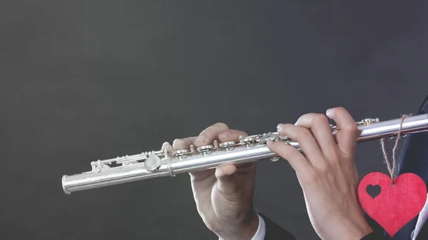 Male flutist with flute and heart. Love melody — Stock Photo, Image