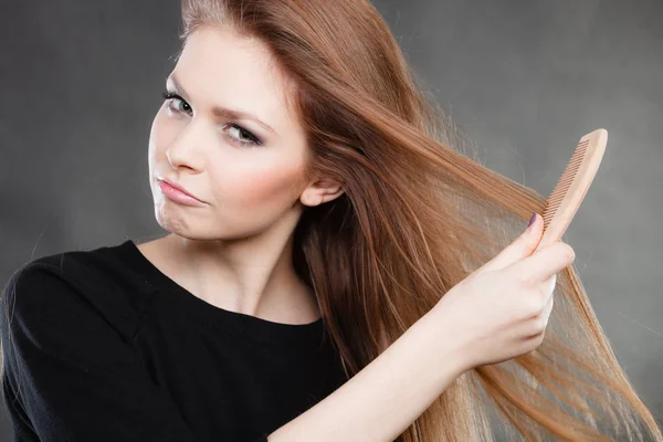 Длинноволосая девушка расчесывает волосы . — стоковое фото