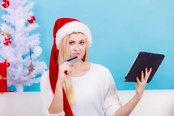 Žena v Santa hat držení tabletu a kreditní karty — Stock fotografie