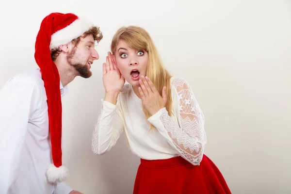 Homem de santa chapéu sussurrando para mulher orelha . — Fotografia de Stock