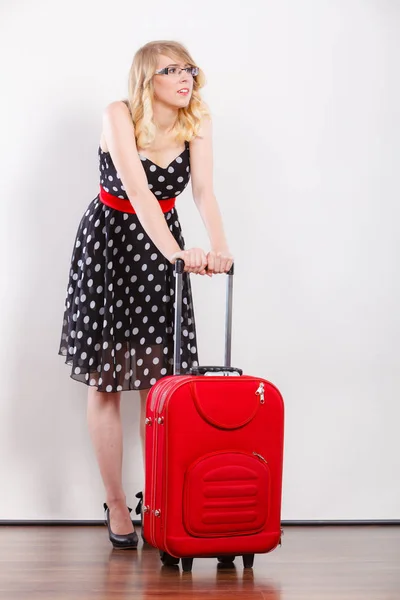 Mujer tirando pesada bolsa de viaje roja — Foto de Stock