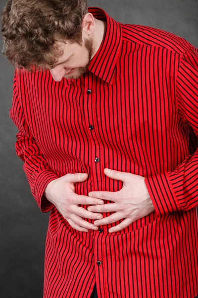 Mann im roten Hemd hat Bauchschmerzen — Stockfoto