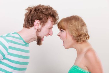 Öfkeli kadın ve erkek birbirlerine bağırıyorlar.