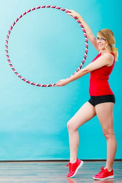 Adatto donna con hula hoop facendo esercizio — Foto Stock
