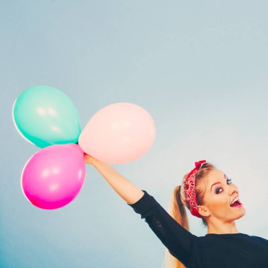 Balonlarla eğleniyor gülümseyen çılgın kız.