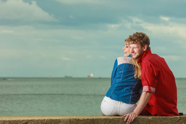 海海岸に座っているカップルを抱きしめ — ストック写真