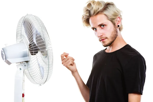 Young man in front of cooling fan — Stock Photo, Image