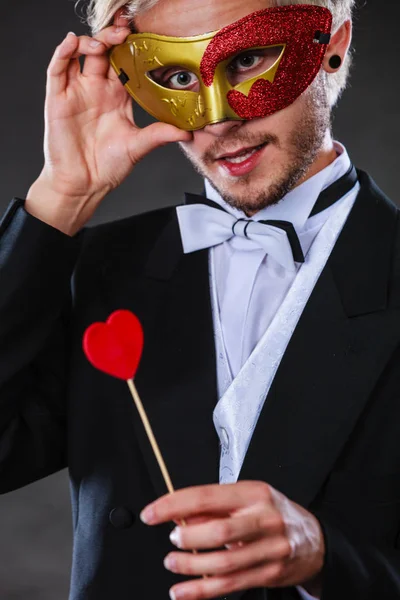 Muž v karnevalové masce s symbol srdce lásce stick — Stock fotografie
