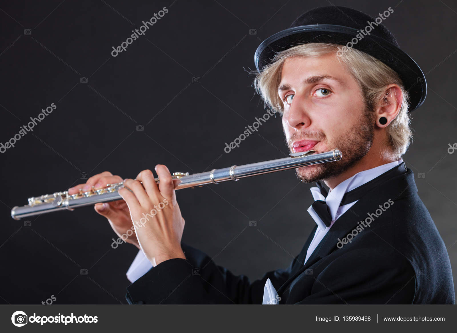 Elegantly dressed male musician playing flute — Stock Photo ©