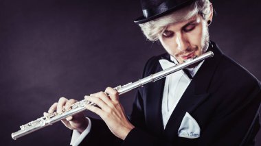 Zarif giyimli erkek müzisyen flüt çalmaya