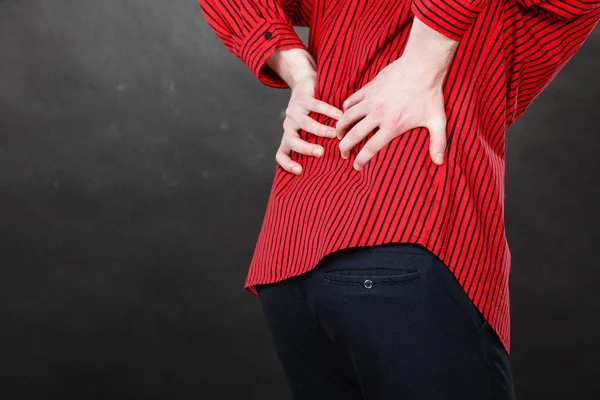 Man in red shirt having back pain — Stock Photo, Image