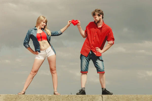 Casal apaixonado detém coração vermelho ao ar livre — Fotografia de Stock