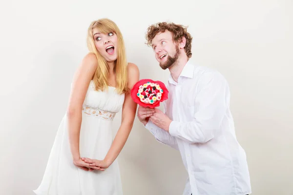 Glückliches Paar mit Süßigkeiten Strauß Blumen. Liebe. — Stockfoto