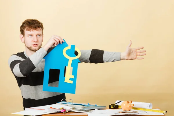 Mann mit Papierhaus und Schlüssel. — Stockfoto