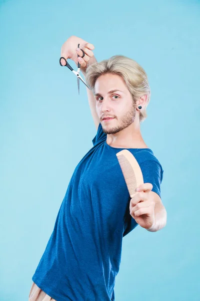 Человек с ножницами и гребнем создает новую прическу — стоковое фото