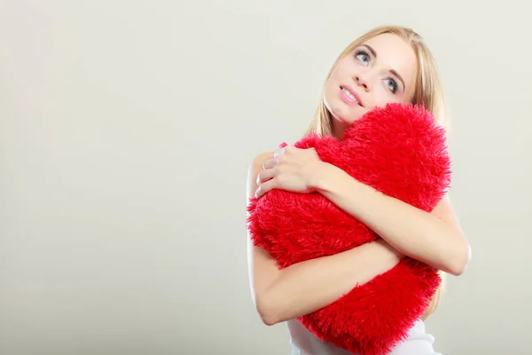 Donna in possesso di cuore a forma di cuscino amore simbolo — Foto Stock
