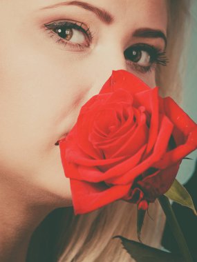 Kırmızı gül çiçek tutan güzel kadın.
