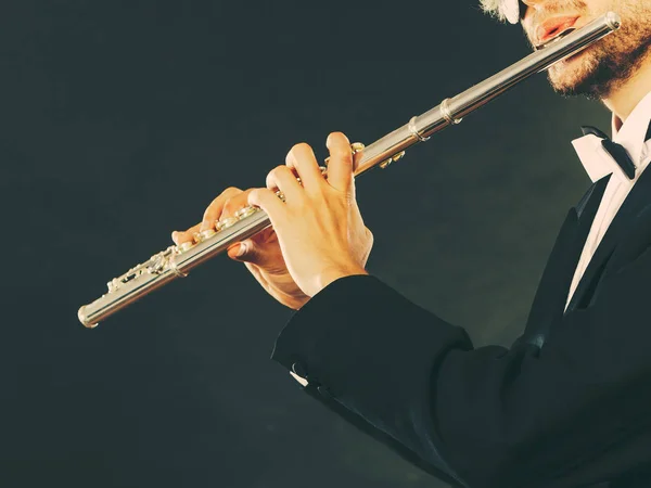 Elegantemente vestido músico masculino tocando flauta — Fotografia de Stock