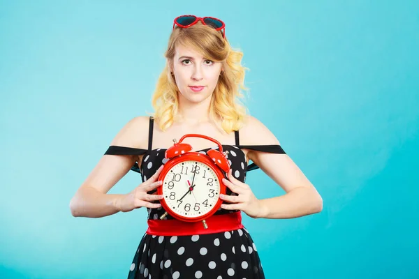 Smiling girl with alarm clock on blue. — Stock Photo, Image