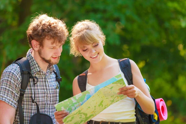 Senderismo mochilero pareja lectura mapa en viaje . — Foto de Stock