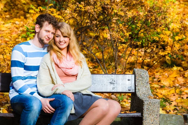 Lovers couple in autumn park on bench — Stock Photo, Image