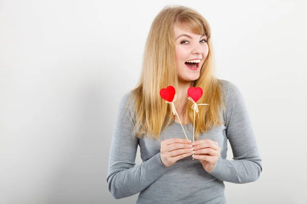 Schönes Mädchen, das mit Herzen auf Stöcken spielt. — Stockfoto