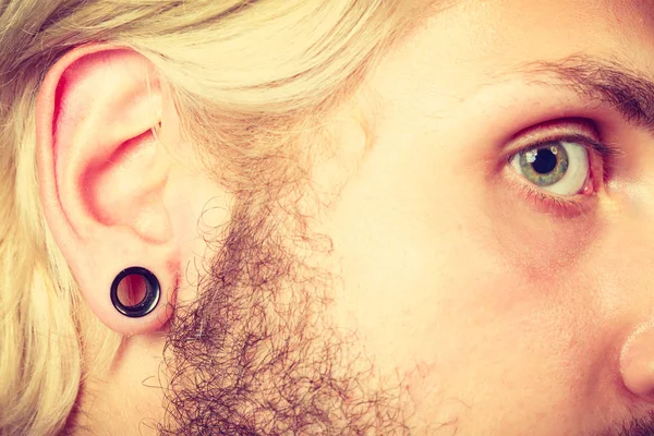 Pierced man ear, black plug tunnel