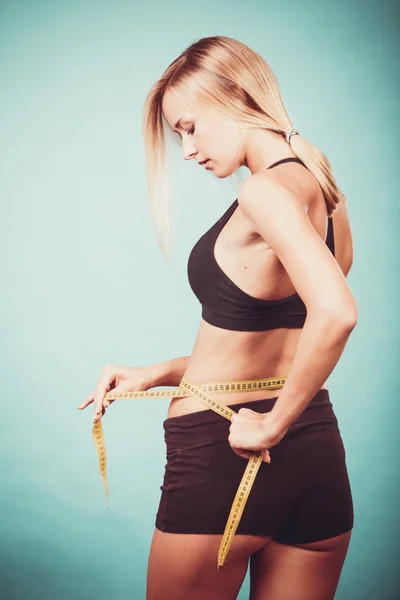 Fitness girl measuring her waistline — Stock Photo, Image