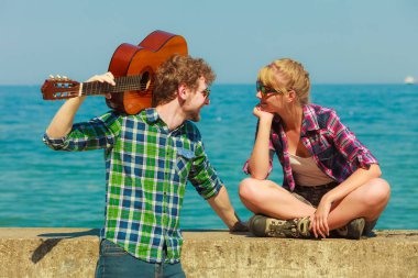 Genç adam onun kız arkadaşı deniz kenarında gitar çalmak