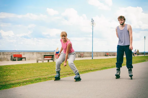 Dos personas corren juntas montando patines . — Foto de Stock