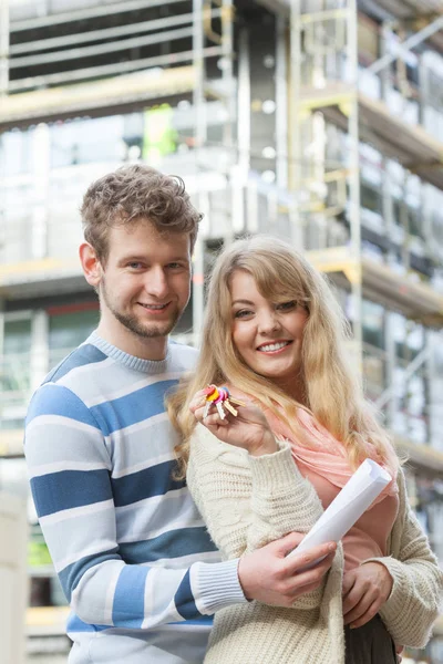 Pareja con llaves en frente de la nueva casa moderna — Foto de Stock