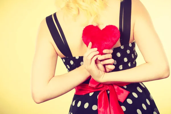 Femme en robe pointillée tenant coeur rouge — Photo