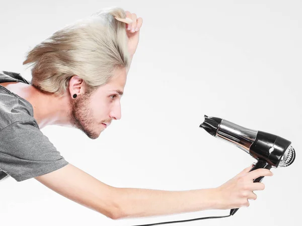 Joven hombre secando el cabello con secador de pelo — Foto de Stock