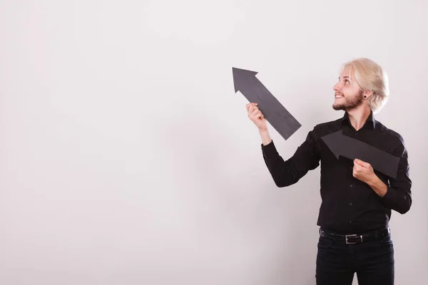 Hombre sosteniendo dos flechas apuntando en la misma dirección — Foto de Stock