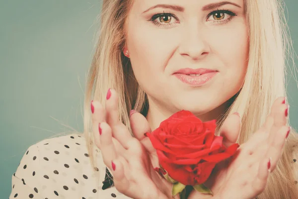 Mulher segurando vermelho rosa flor no azul — Fotografia de Stock