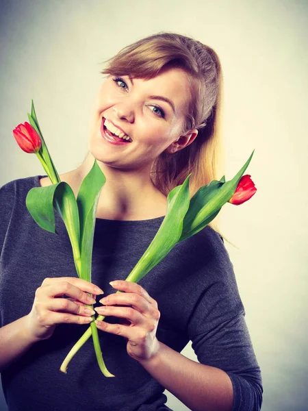 Ευτυχισμένη ξανθιά γυναίκα με λουλούδι άνοιξη. — Φωτογραφία Αρχείου