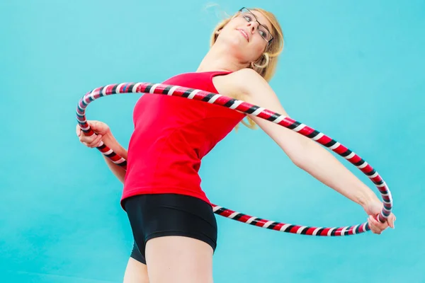 Adatto donna con hula hoop facendo esercizio — Foto Stock