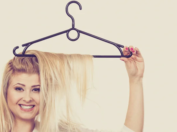 Mulher loira com cabelo no cabide de roupas — Fotografia de Stock