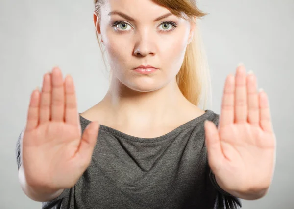 Vrouw toont stopbord door haar hand. — Stockfoto