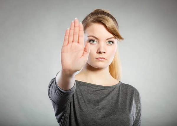 Vrouw toont stopbord door haar hand. — Stockfoto