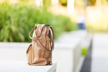 Beyaz çıkıntının üzerinde küçük kahverengi sırt çantası duran