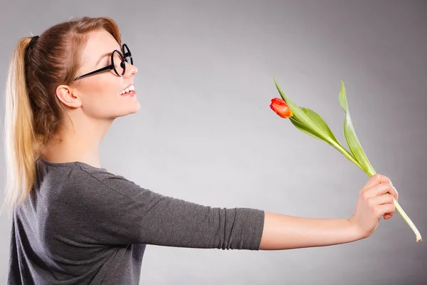 Sorrindo senhora cheirando flor . — Fotografia de Stock