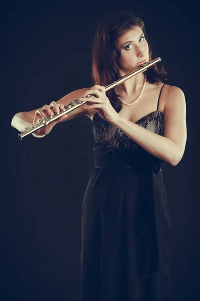 Woman playing transverse flute on black. — Stock Photo, Image