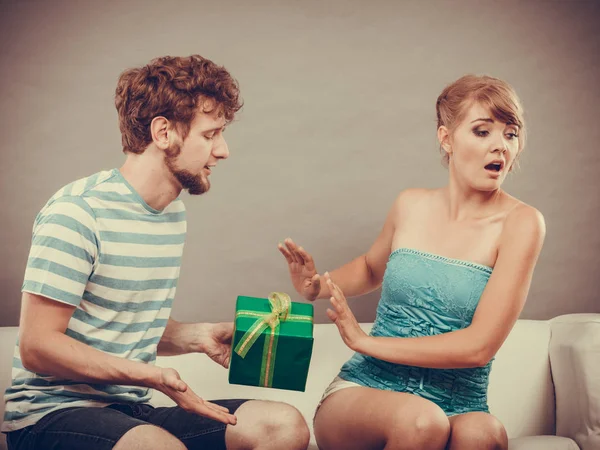 Young man giving offended woman gift box — Stock Photo, Image