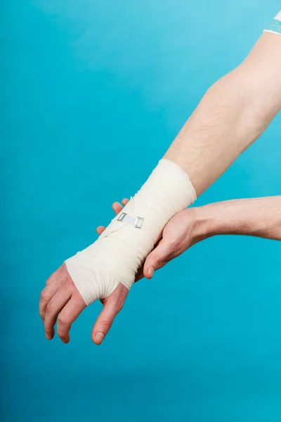 Man med smärtsamma bandagerade hand. — Stockfoto