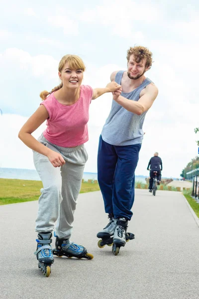 Mujer animar al hombre a hacer patinaje — Foto de Stock